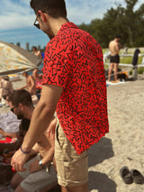 zeidmoon on a beach in a red 90's pattern vintage style hawaiian shirt