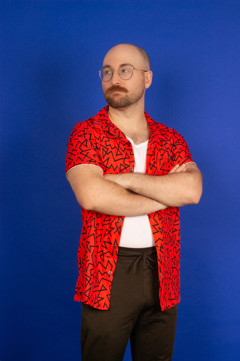 bald man in a red 90's pattern vintage style hawaiian shirt